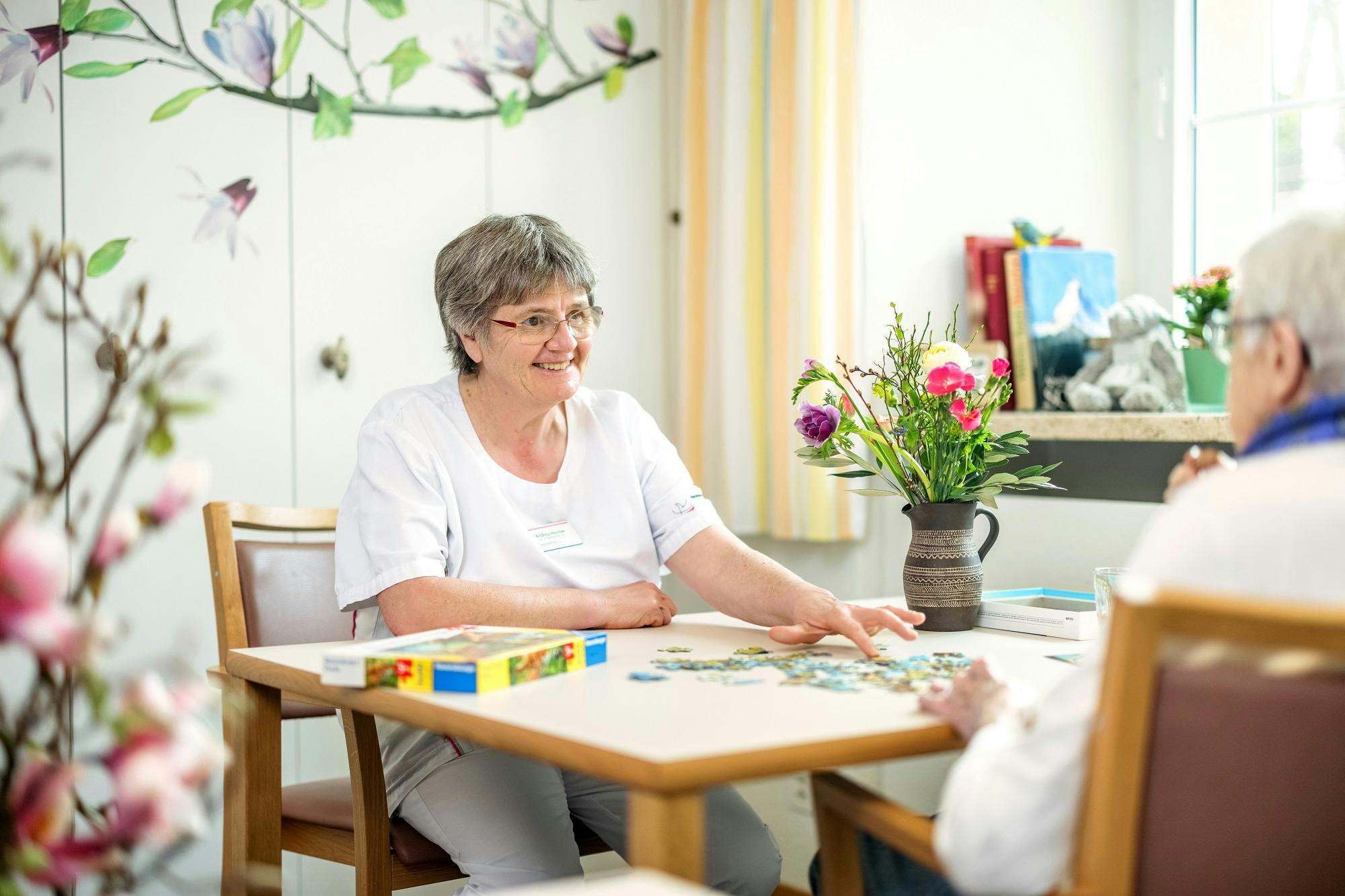 Seniorin beim Puzzlespiel in einem hellen Raum